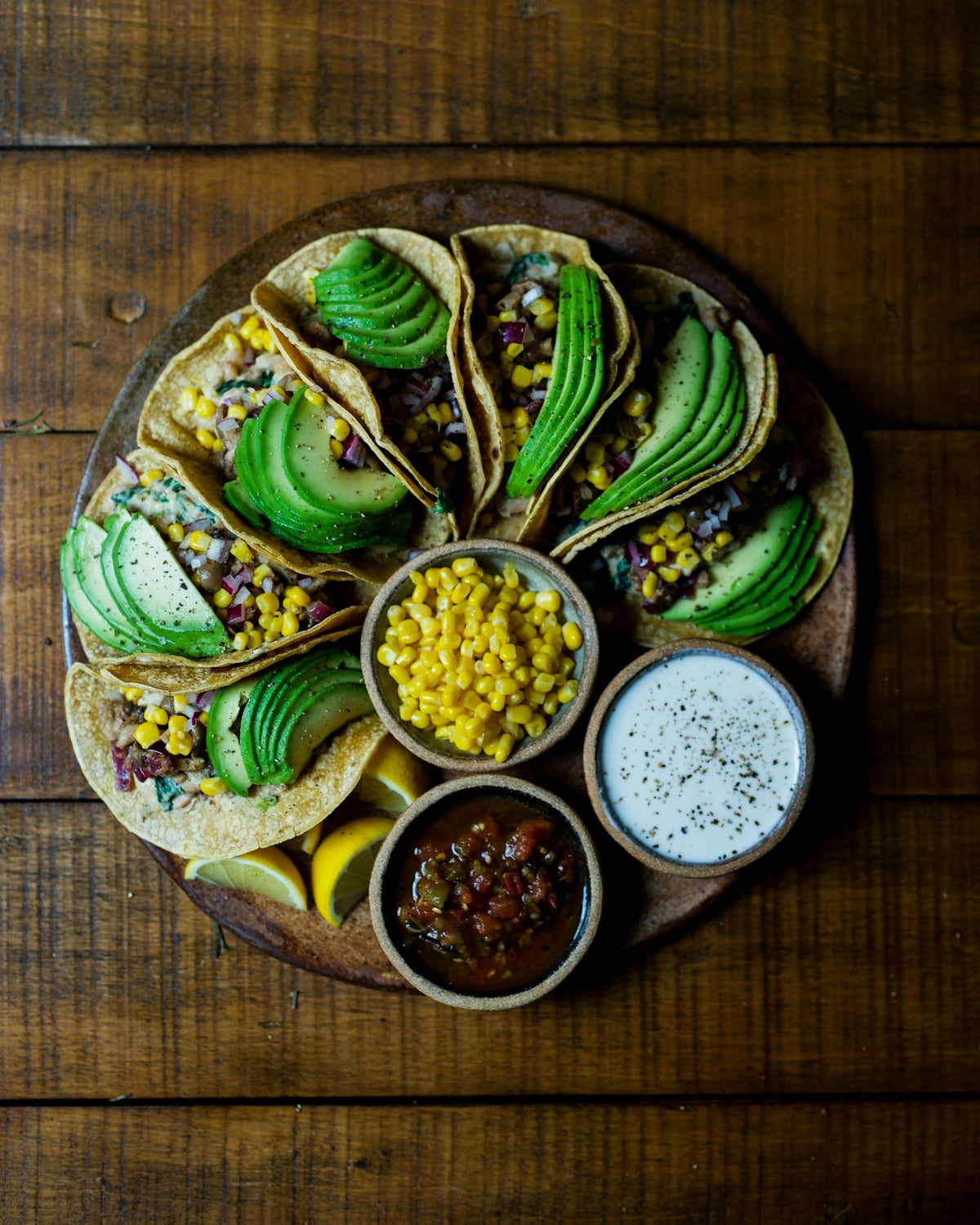 Tacos mit Mais, Avocado und frischen Toppings auf einem Sharing-Tisch